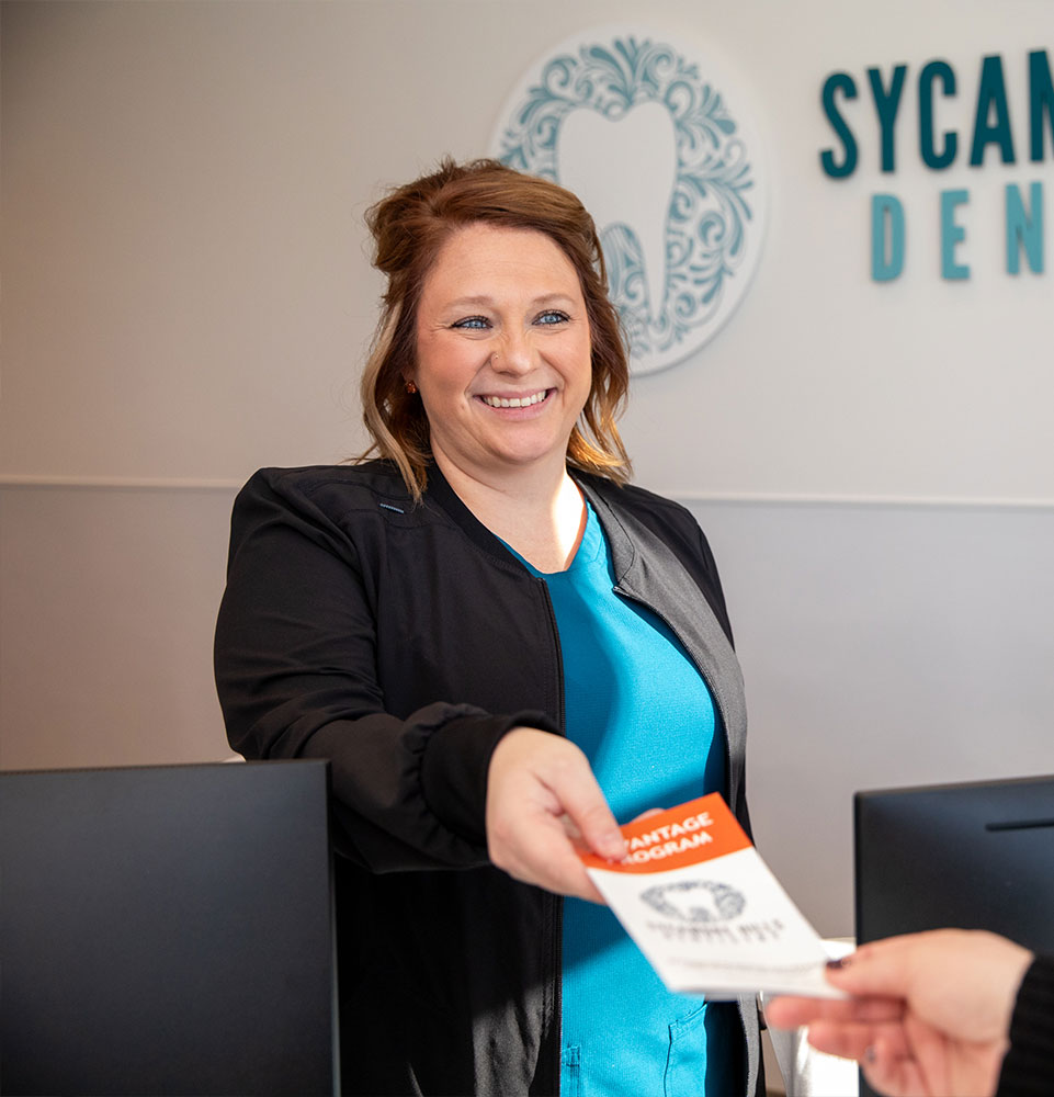 staff member helping patient at the front desk within the dental center