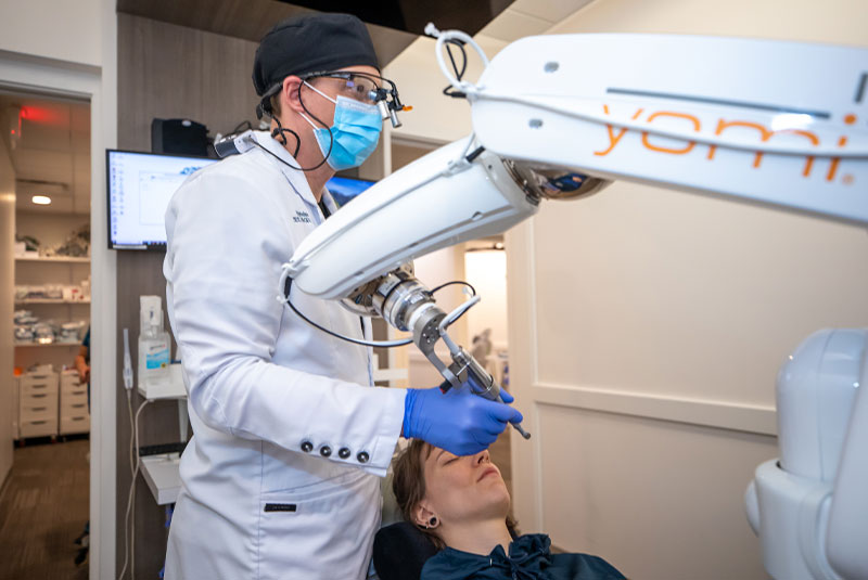 dentist holding yomi robot
