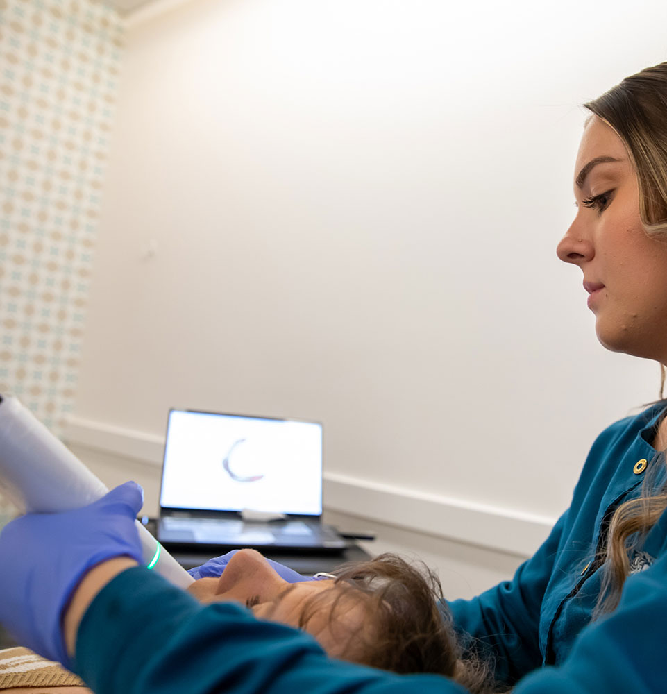 Team member taking a 3d scan of patients teeth